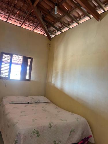 a small bedroom with a bed and a window at Chácara Marias Da Serra in Araruna