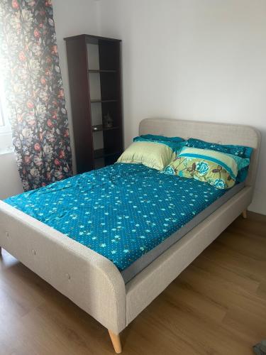 a bed in a bedroom with a blue blanket on it at Apartamenty Leszczynowa in Łomża