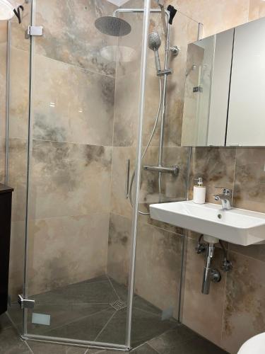a bathroom with a shower and a sink at Apartamenty Leszczynowa in Łomża
