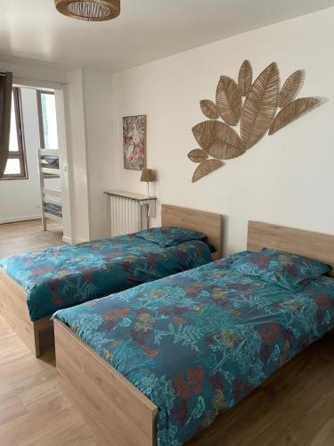 a bedroom with two beds with blue sheets at L'Ecrin du Chalet d'Arguel in Pugey