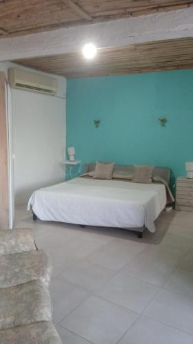 a bedroom with a white bed and a blue wall at Seesterne in Estrela