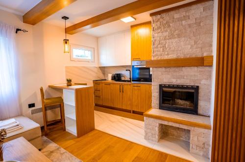 a kitchen with a stone fireplace and a counter at Wolf Apartments Zabljak in Žabljak