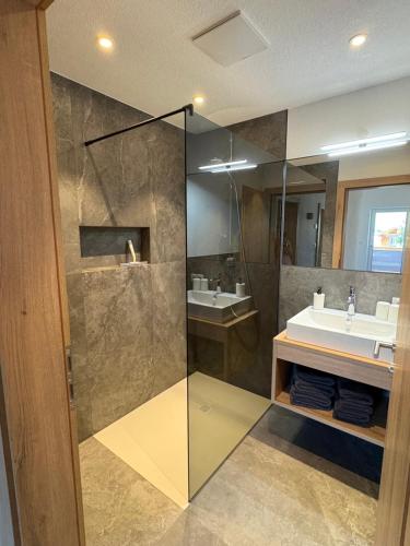 a bathroom with a glass shower and a sink at 6444 Apartment in Unterlängenfeld