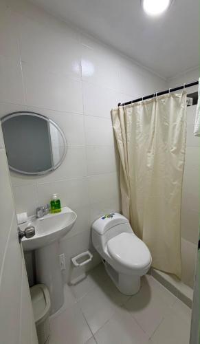 a bathroom with a toilet and a sink and a mirror at Hotel Boutique Trinitarias in Valledupar