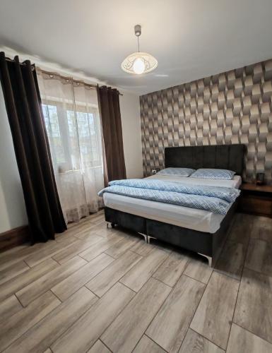 a bedroom with a bed and a wooden floor at Casa Mia in Câmpulung Moldovenesc