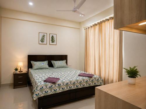a bedroom with a bed and a table with a plant at The Azure Loft Nestory Stays in Rājpur