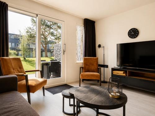 a living room with a large flat screen tv at Prins Heerlijk Amelander Kaap 81 in Hollum