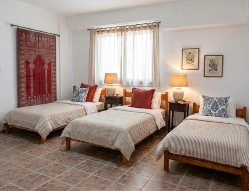 a living room with three beds and a couch at Dreamcatcher Maizonette No. 3 in Kalavrita