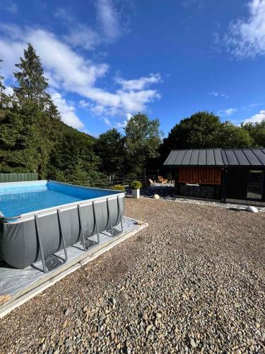 a swimming pool with chairs next to a building at Chalet Tukhlya in Tukhlya