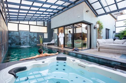 a woman standing in a swimming pool next to a house at Naomi Boutique Suites in Netu'a