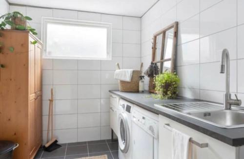 a kitchen with a washing machine and a sink at Villa in Gothenburg in Gothenburg