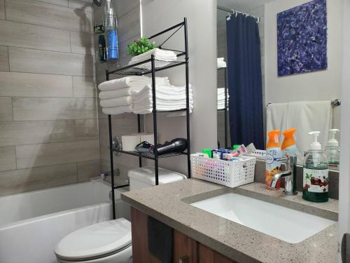 a bathroom with a sink and a toilet and a shower at Plush Suite Pet Friendly 326 Mbps Wi-Fi in Airdrie