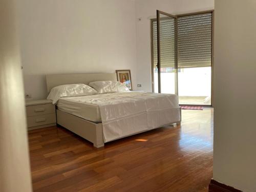 a bedroom with a bed and a wooden floor at Vila Konti 42 in Durrës