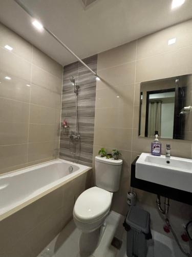 a bathroom with a toilet and a tub and a sink at 8 Newtown Mactan in Pajo