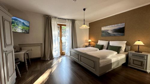 a bedroom with a large white bed and a window at Gästehaus Zoller - Rettenberg im Allgäu in Rettenberg