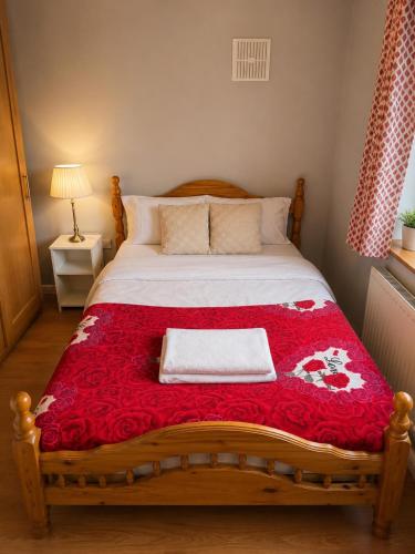 a bedroom with a bed with a red blanket at North Dublin 2-Bed House Sleeps 4 in Dublin