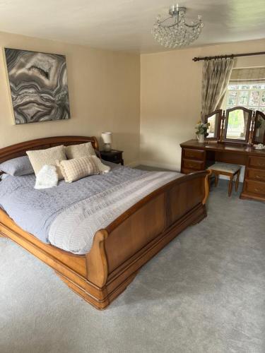 a bedroom with a large wooden bed and a desk at West Cottage, Free Breakfast supplied with free range eggs With log burner in Towton