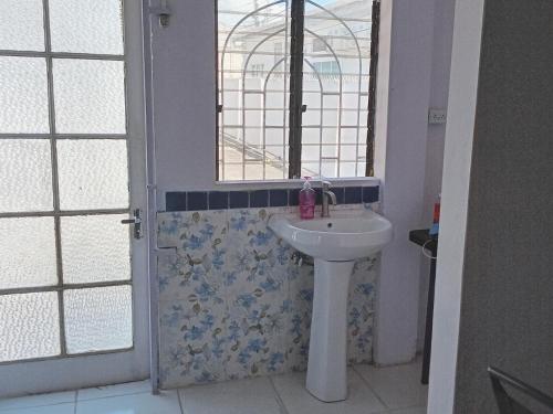 a bathroom with a sink and a window at Gazebo in Port-of-Spain