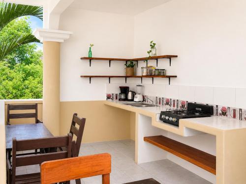 a kitchen with a stove and a table and chairs at Punta Sol in Brisas de Zicatela