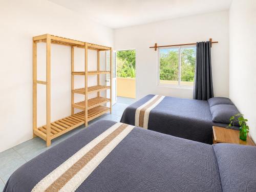 a room with two beds and a couch and a window at Punta Sol in Brisas de Zicatela