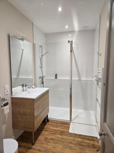 a white bathroom with a sink and a shower at Chez mamie in La Rochelle