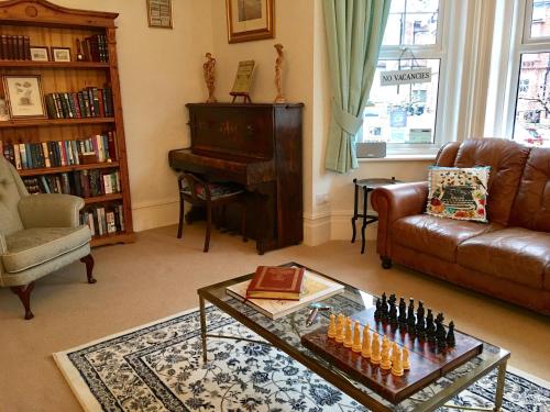 a living room with a couch and a chess board on a table at The Cherry Tree Guest House in Eastbourne