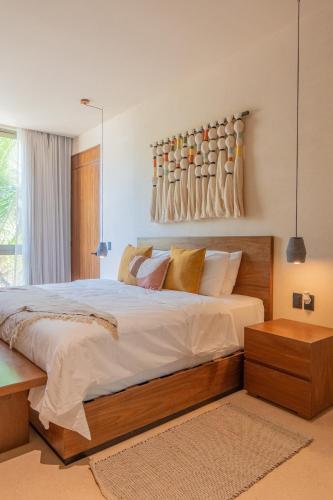 a bedroom with a large bed and a wall with vases at PenthouseLuxury - Laguna PoolPriv Paddles in Bacalar