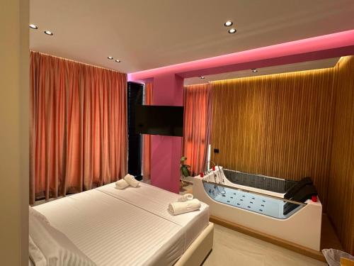 a bedroom with a bed and a tub in it at Hotel Kloi - Rooms & Jacuzzi Vlore in Vlorë