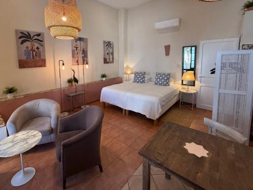 a bedroom with a bed and a table and chairs at Darcilla Guest House in Tarifa