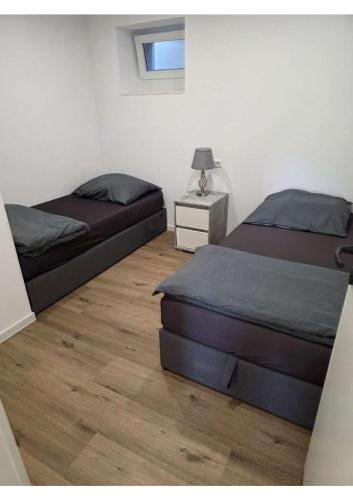 a bedroom with two beds and a table with a lamp at YourHome 2 in Haigerloch