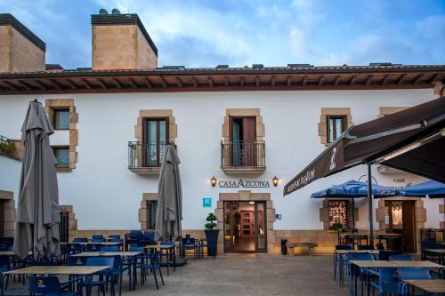 a restaurant with tables and umbrellas in front of a building at Hotel Casa Azcona in Zizur Mayor