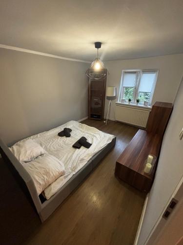 a bedroom with a bed with two black shoes on it at Apartamenty Trzcińsko 47 in Janowice Wielkie
