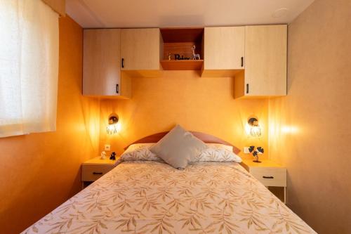 a bedroom with a bed with white pillows and cabinets at Villa Thiago in Cádiz