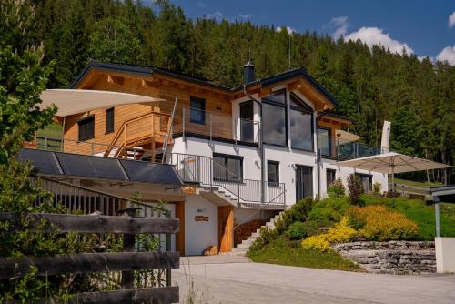 a house on a hill with a forest at Austrian Alpine Apartments in Ramsau am Dachstein