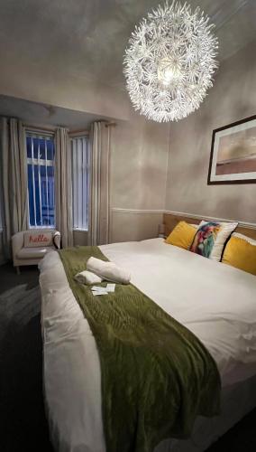 a bedroom with a large bed and a chandelier at Cherish Lewis Hotel- Hull Road, Blackpool Central in Blackpool