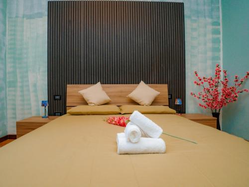 a bedroom with a large bed with towels on it at LA CORTE CHARME Diaz in Ravenna