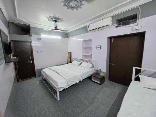 a room with two beds and a door to a bedroom at Saira Mahal HOTEL in Ajmer