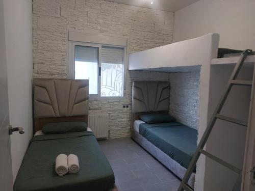 a bedroom with two bunk beds and a window at Casa Tanger in Tangier