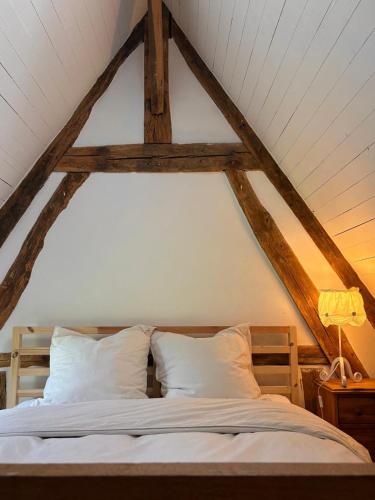 a bedroom with a white bed with a wooden frame at Dreamy Perche landscape in Bivilliers