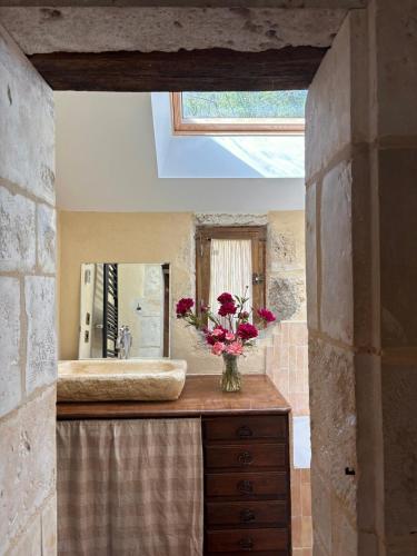 a bathroom with a sink and a vase of flowers on a counter at Dreamy Perche landscape in Bivilliers