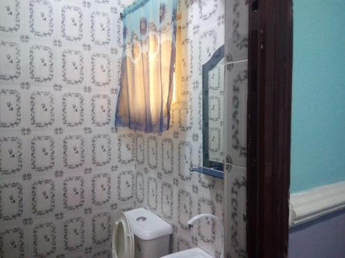 a bathroom with a toilet and a mirror on the wall at Lakewood Hotels in Port Harcourt