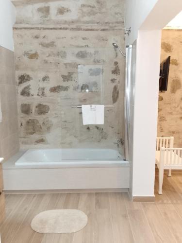 a bath tub in a bathroom with a stone wall at Convento Tarifa in Tarifa