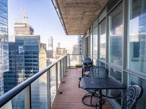 a balcony with two chairs and a table on a building at Pristine Modern 2BR Condo Private BBQ and Balcony in Toronto