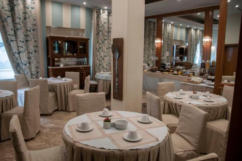 a restaurant with white tables and chairs and a counter at Esperia Boutique Hotel in Agrinion