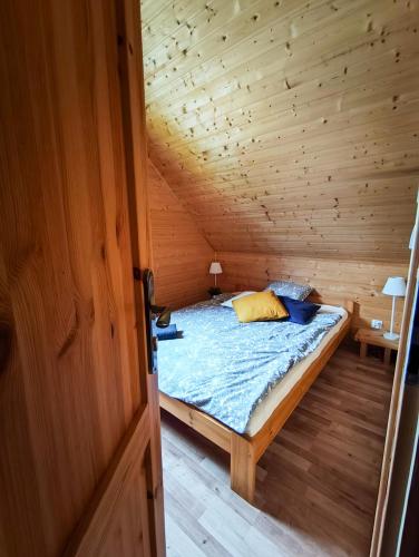 a bedroom with a bed in a wooden room at Domki Sielankowo in Odargowo