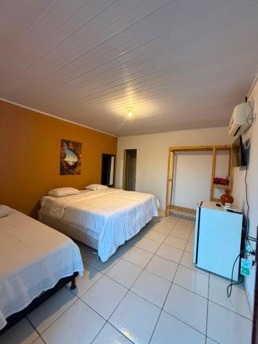 a hotel room with two beds and a tv at Pousada Villa Cerrado in Caldas Novas