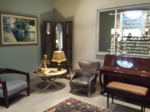 a living room with a piano and a chair at Esperia Boutique Hotel in Agrinion