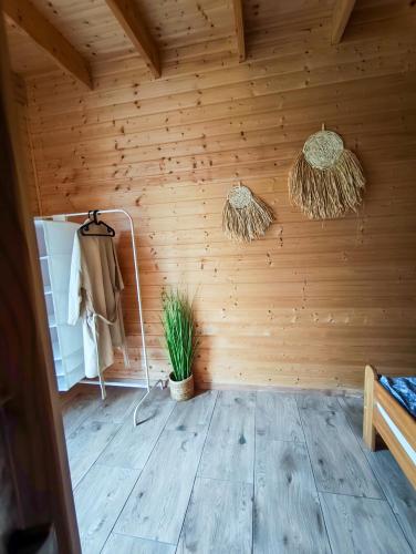 a room with a wooden wall with a plant in it at Domki Sielankowo in Odargowo