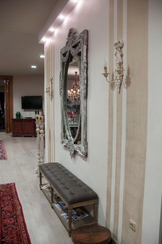 a mirror on a wall with a bench in a room at Esperia Boutique Hotel in Agrinion