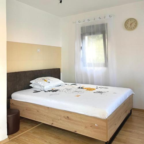 a bed with a wooden frame in a room at Blue Bay Apartments in Krašići